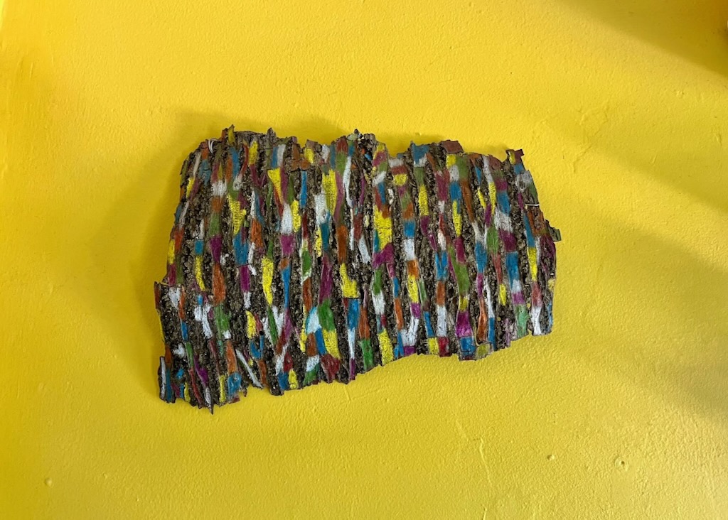 Colorful textured fabric piece on yellow background.