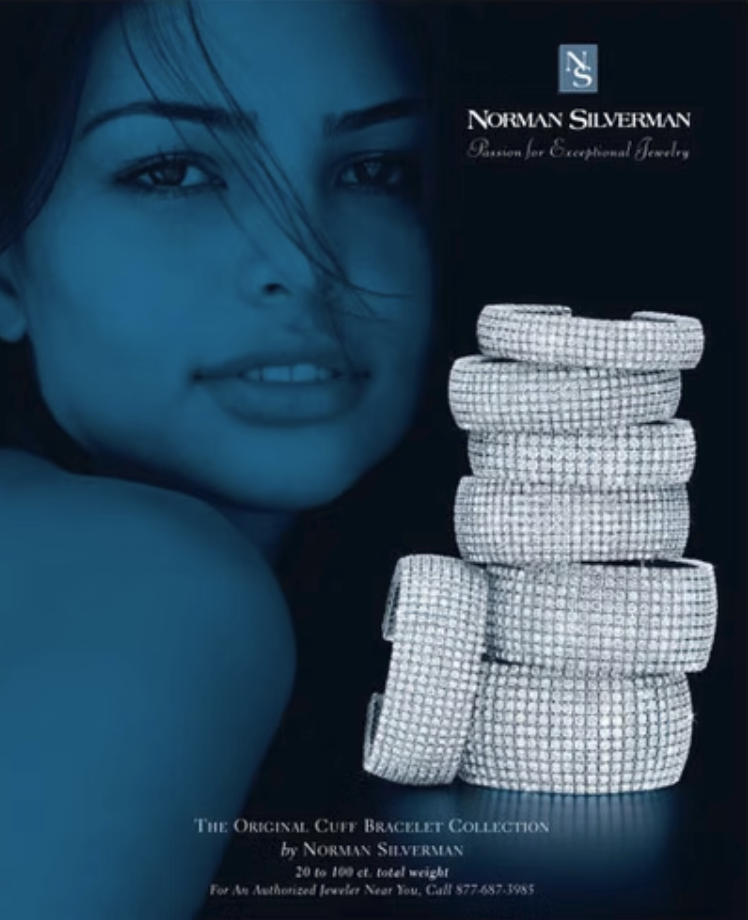 Close-up of a woman's face with dark hair, and a stack of white bracelets with textured patterns beside her.