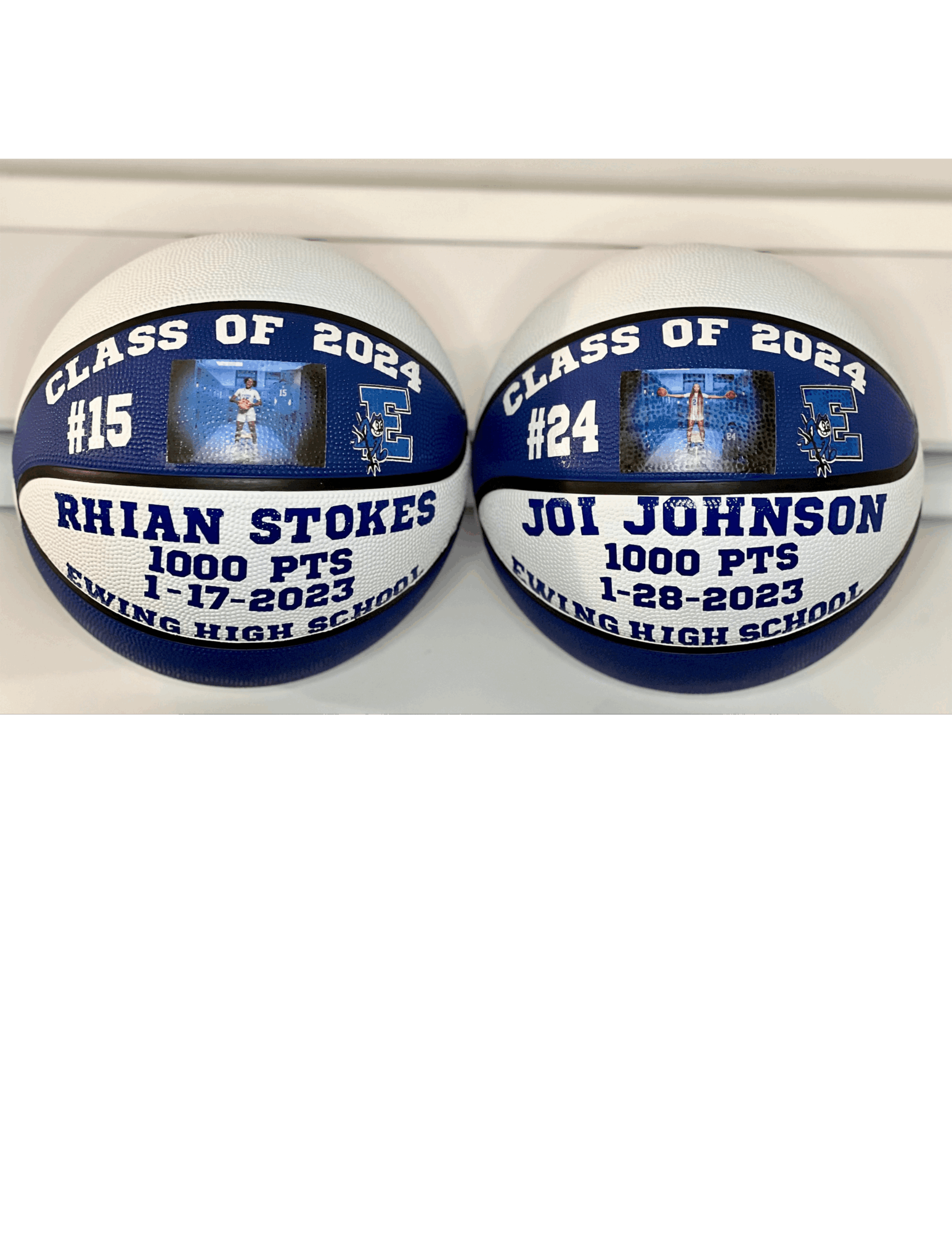 Two decorated white basketballs with graduation theme, names, and photos, placed on a shelf. One for Rhiann Stokes, one for Joy Johnson.