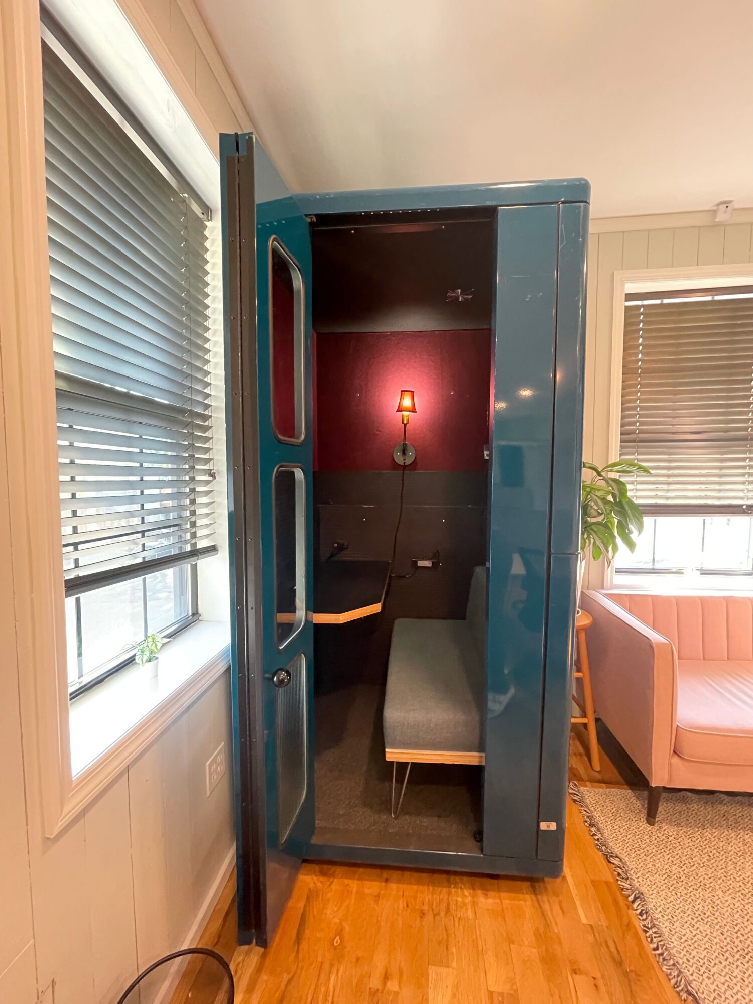 A blue vending machine with a glass front, showing empty interior and a small wooden shelf inside.