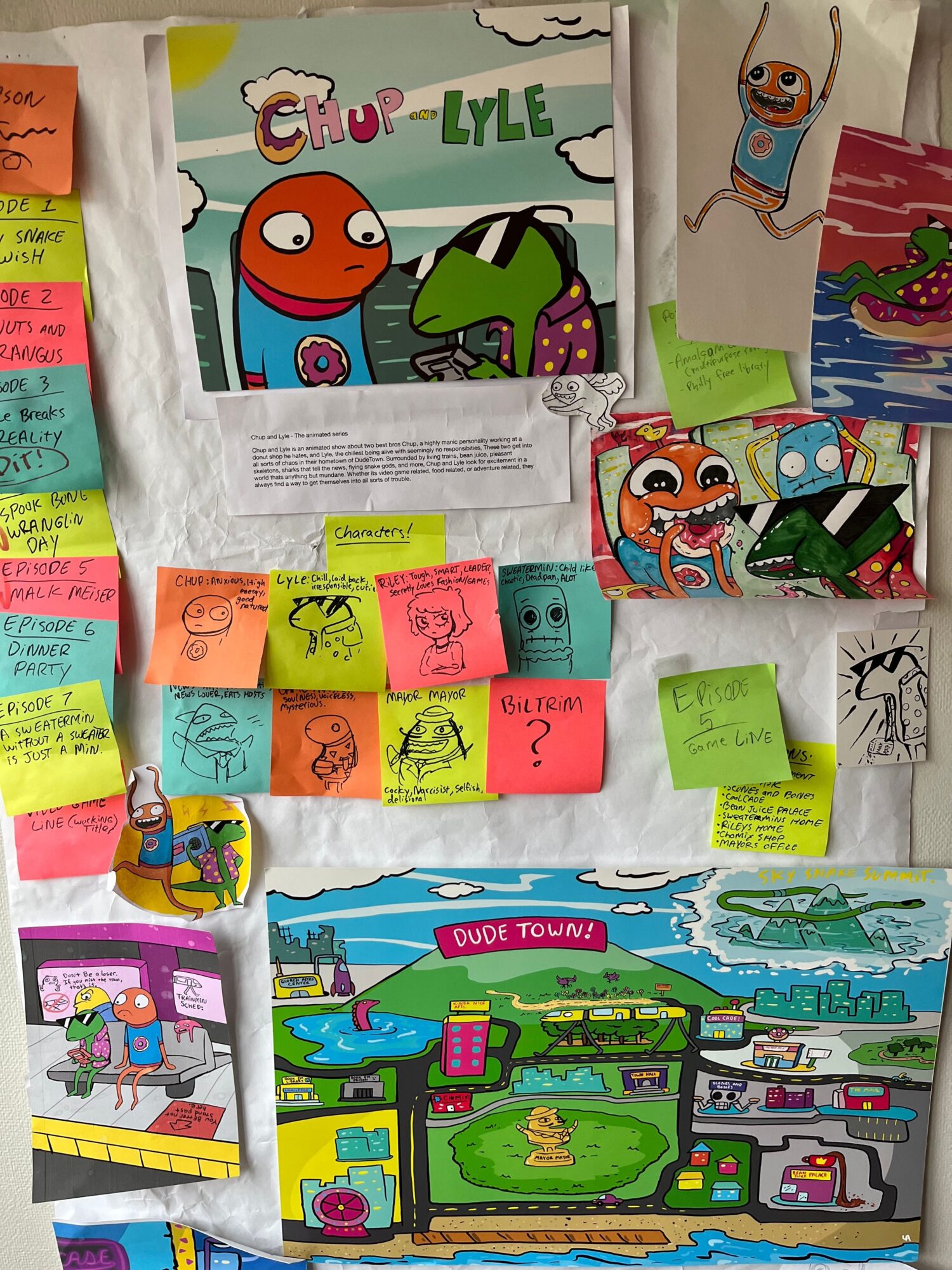 Colorful children's drawings and notes with sticky notes on a wall, including cartoon characters and a cityscape scene.