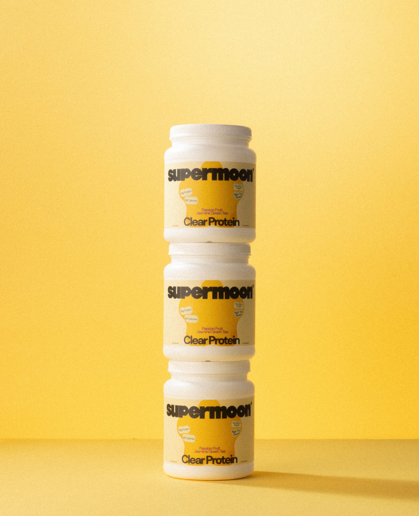 Three stacked containers with yellow and black labels against a yellow background.