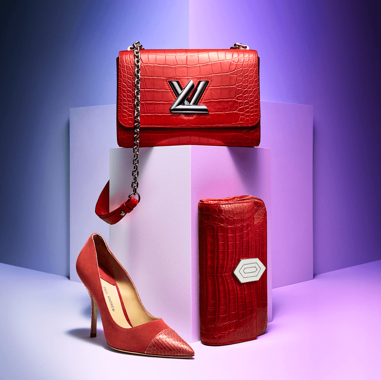 Red handbag with chain strap, red high heel shoe, and red wallet displayed on white blocks against a purple background.