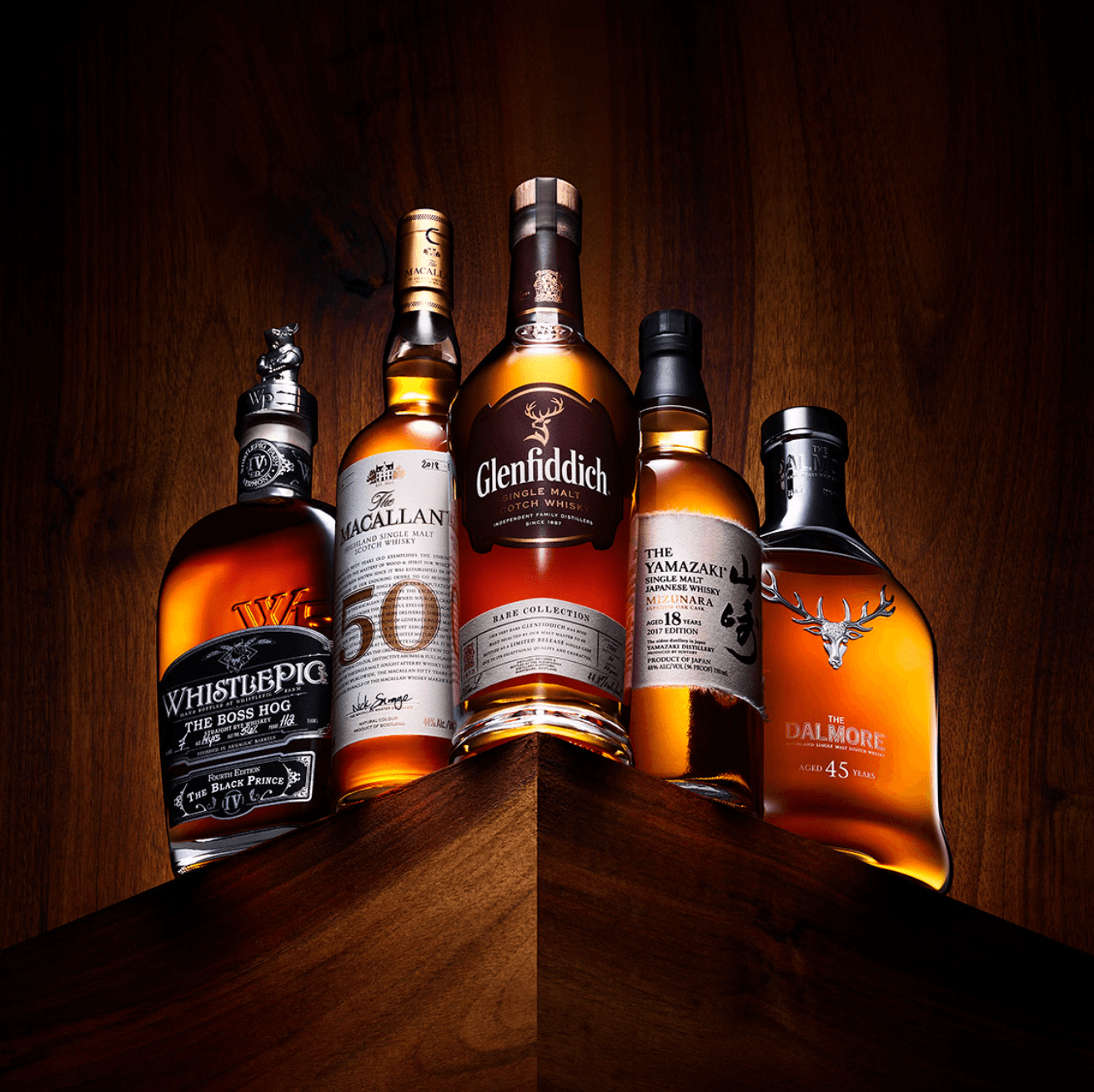Six bottles of whiskey arranged on a wooden surface with a dark background.