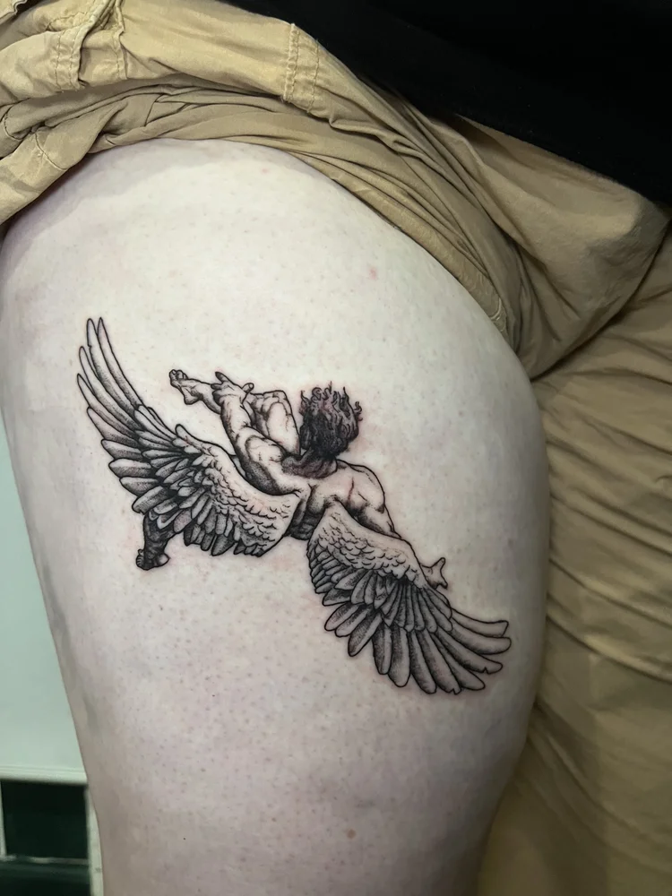 Tattoo of a person with wings, holding a bird, on upper thigh, with detailed line work and shading.