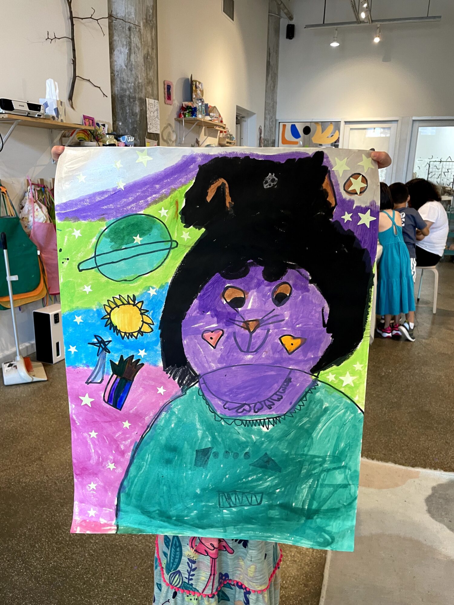 Colorful painting of a person with purple face, black hair, and a green shirt, surrounded by planets, stars, and rainbow.